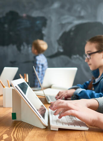 Kinder sitzen im Klassenzimmer vor dem Tablet 