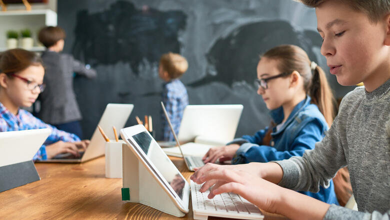 Kinder sitzen im Klassenzimmer vor dem Tablet 