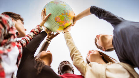 Hände halten einen Globus hoch (Foto: iStock.de/franckreporter)